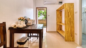 A hallway with a wooden table, a trash bin, and a shelf unit. - The Bulin Residence (Koh Samui)