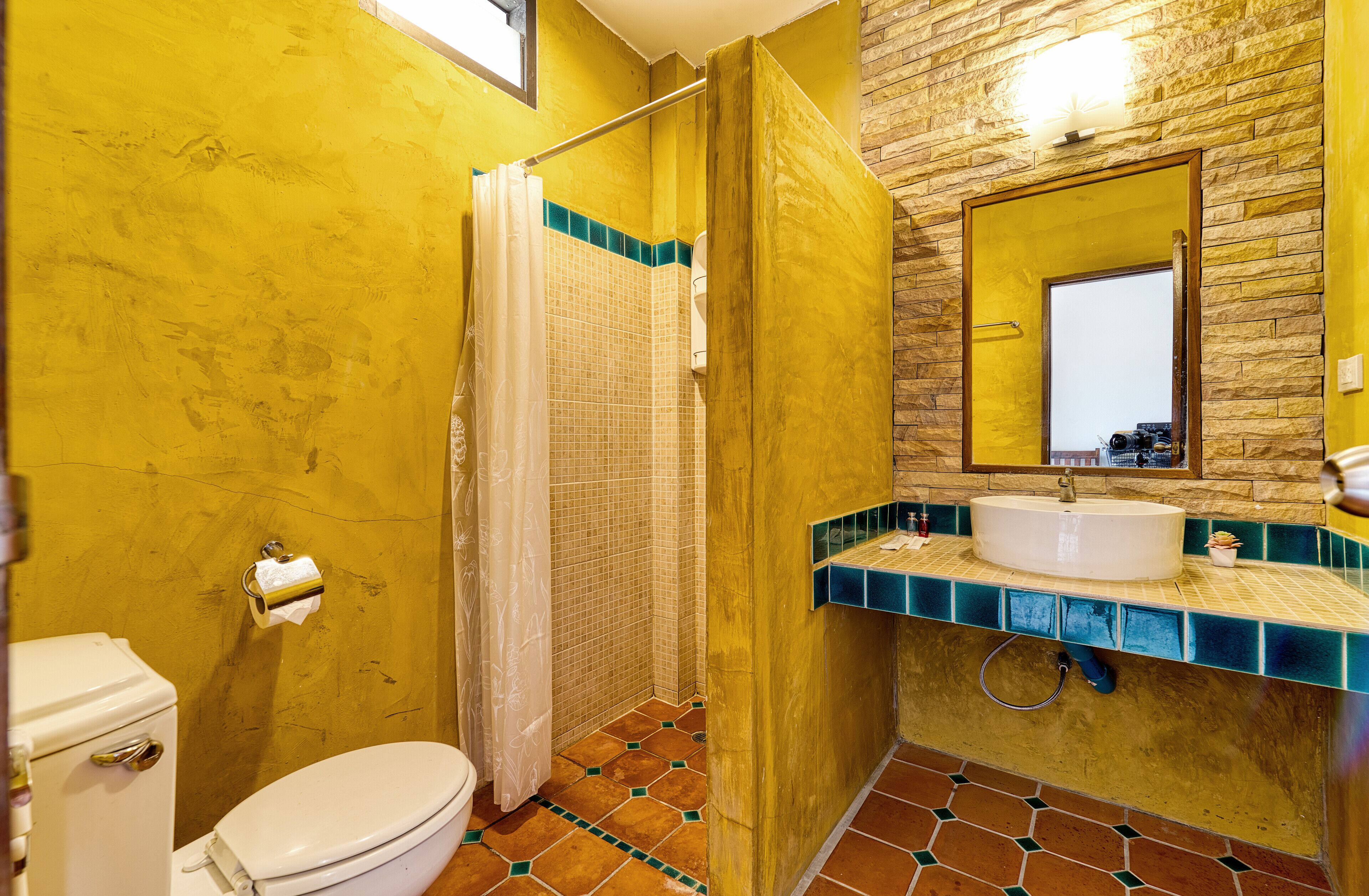 A bathroom with a toilet, shower, and sink.
