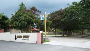 Schild für das Sayong Resort mit Logo und blauem Informationsschild.