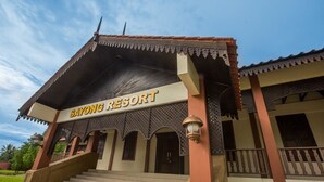 Ein Gebäude mit der Beschriftung "SAYONG RESORT", einem überdachten Eingang und einer Veranda mit dekorativer Geländer.