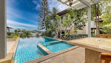 Una piscina al aire libre, sillones reclinables de piscina