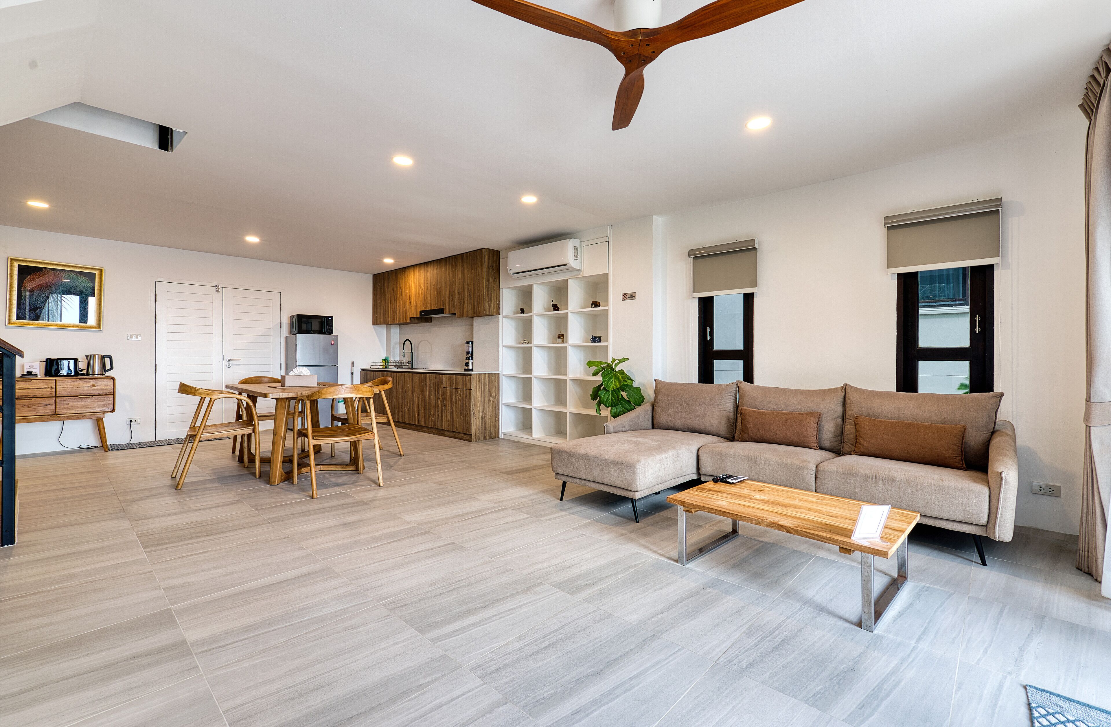 Uma sala moderna com sofá, mesa de centro e área de jantar com cadeiras.