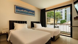 A hotel room with two beds, a painting on the wall, and a view of the outside balcony. - Red Door (Bangkok)