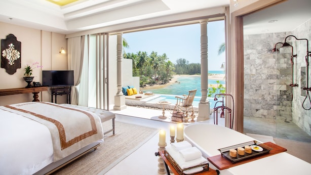 A hotel room with a bed, a TV, a bathroom with a shower, and a view of the beach. - Devasom Khao Lak Beach Resort & Villas (Takua Pa)