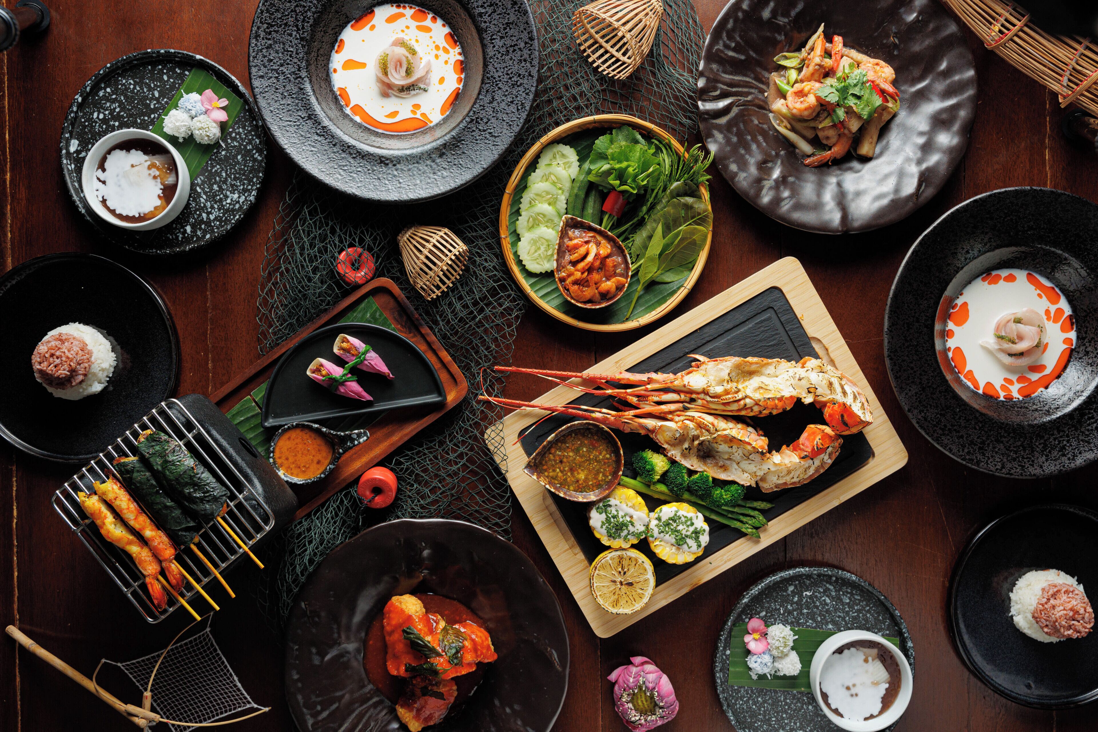 A variety of dishes and seafood arranged on a wooden table.