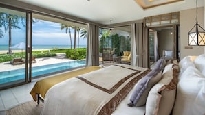 Un dormitorio con una cama grande, vista a la playa y una piscina.