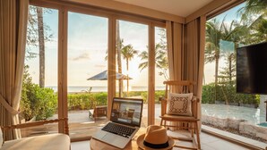 A room with a laptop on a table, a rocking chair, and a view of the ocean. - Devasom Khao Lak Beach Resort & Villas (Takua Pa)