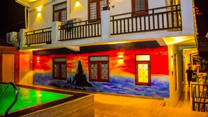 A two-story building with a swimming pool, a balcony, and a mural on the exterior wall. - Asian Grand Hotel (Negombo)