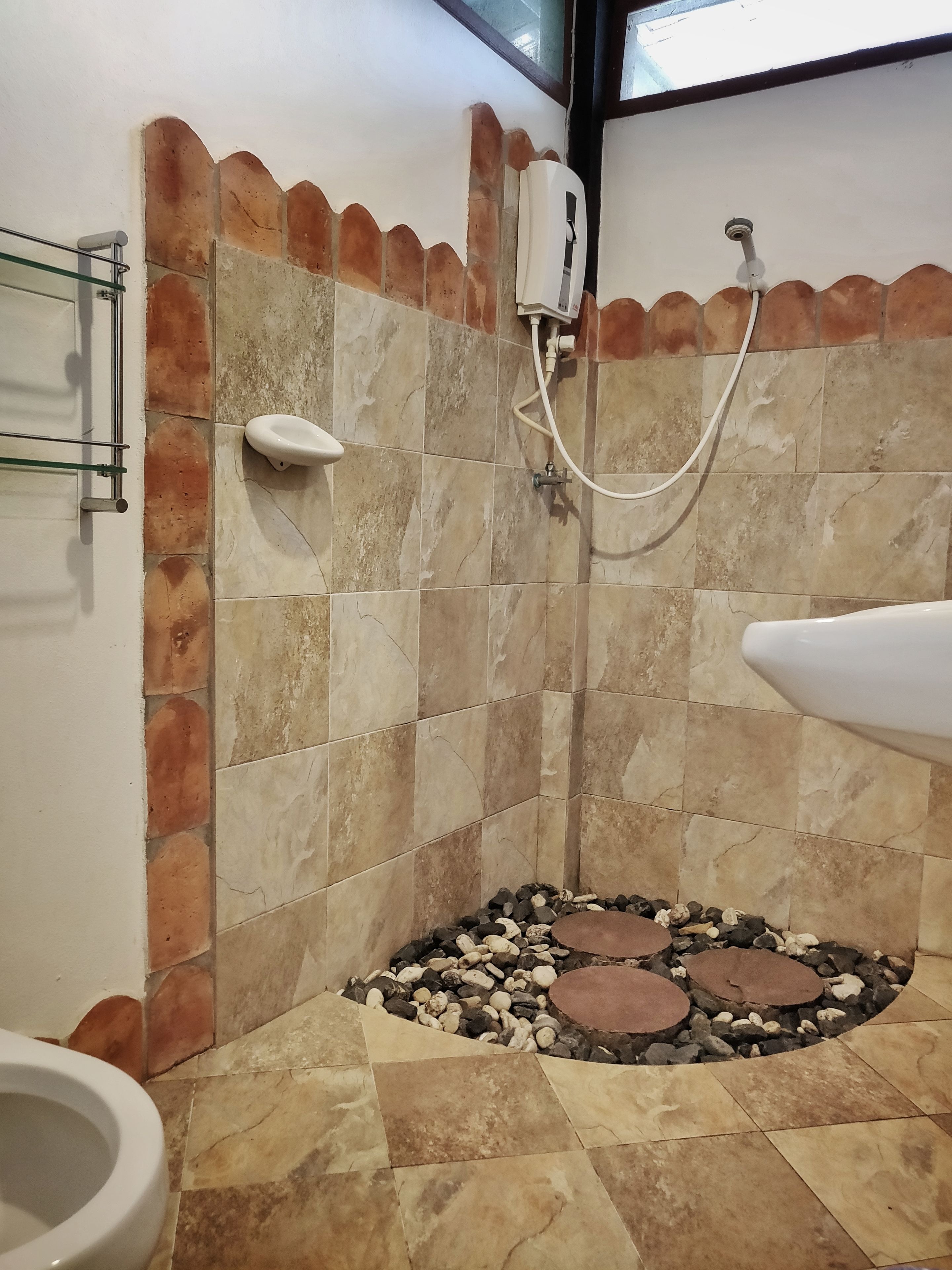 A bathroom with a shower, a toilet, and a sink.
