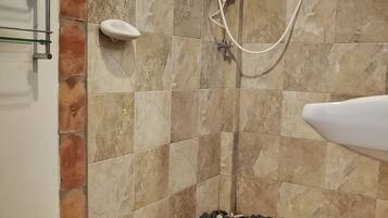 A bathroom with a shower, a toilet, and a sink.