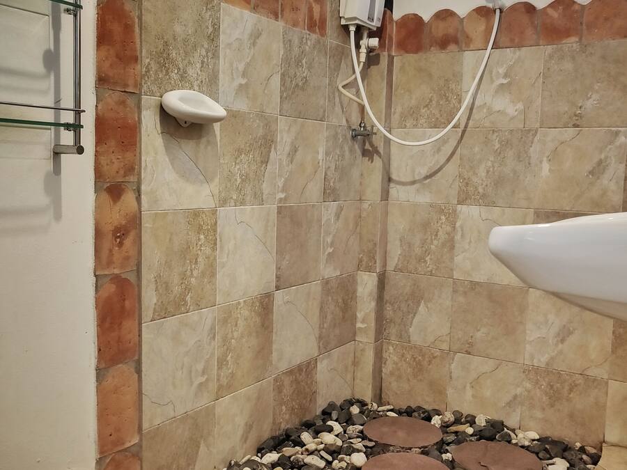 A bathroom with a shower, a toilet, and a sink.