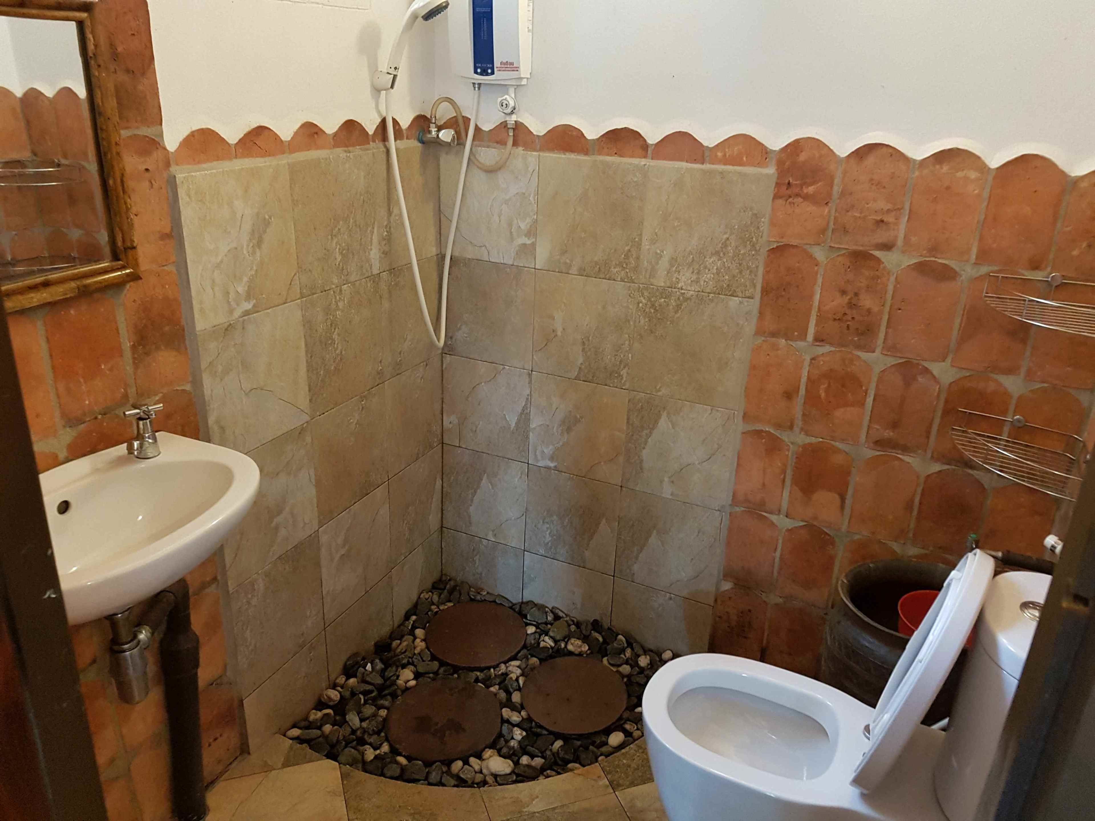 Een badkamer met een douche, een wastafel en een toilet.