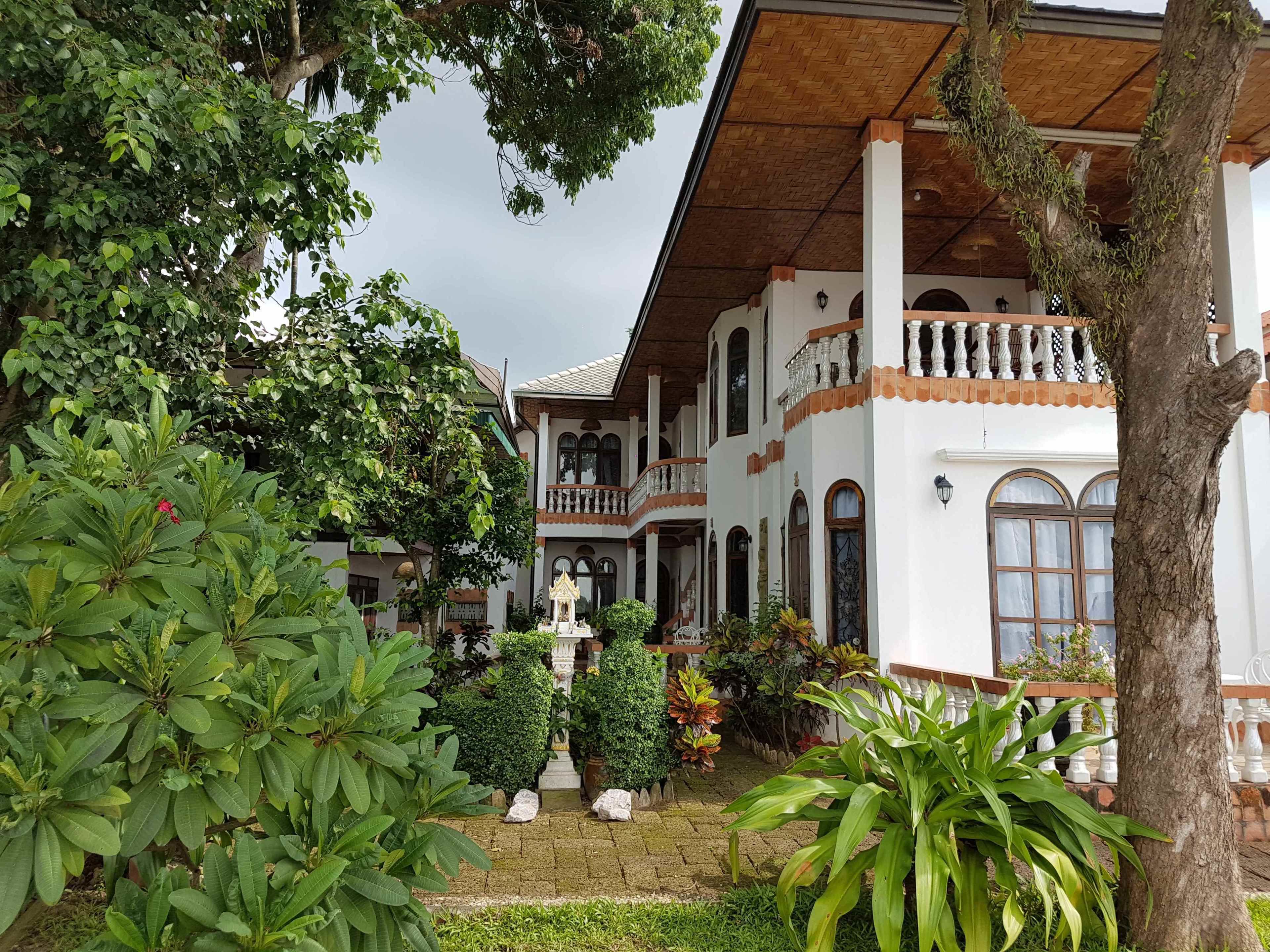 A traditional building with a white facade, multiple balconies, and a central courtyard with a fountain.