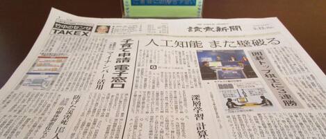 Un periódico con texto en japonés, sobre una mesa.