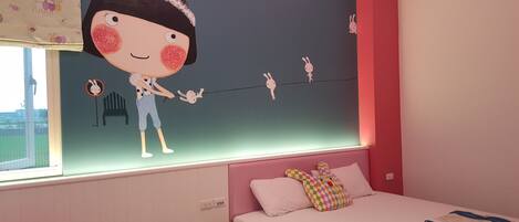 A bedroom with a bed, a window, and a wall with a cartoon character.