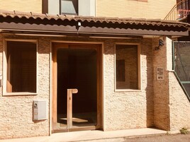 Un edificio con tetto in tegole, una porta in legno e due finestre.