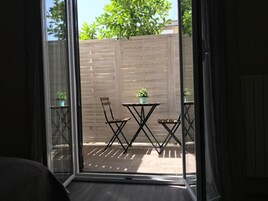 Una stanza con una porta scorrevole in vetro che si apre su un patio esterno.