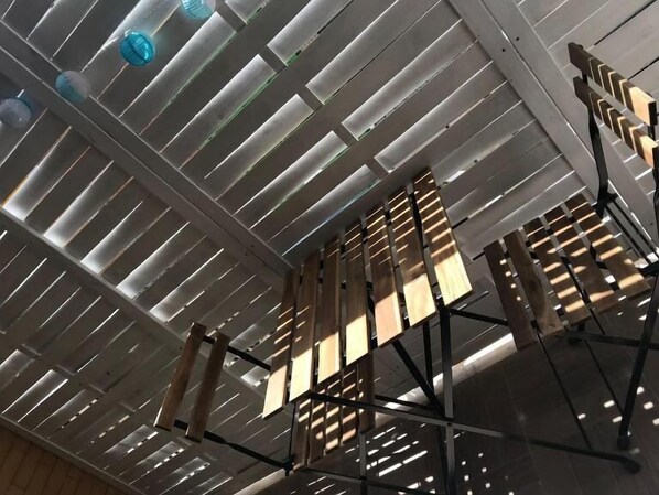 A ceiling with horizontal slats and hanging light fixtures.