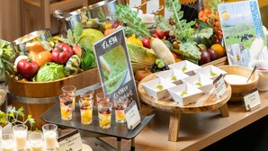 Una mesa de buffet con diversas frutas, verduras y bebidas.