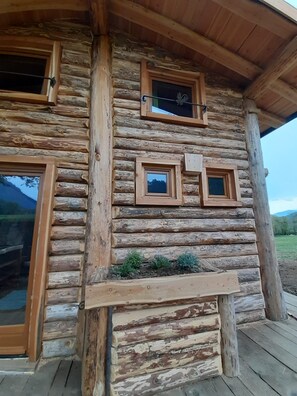 Eine rustikale Holzhütte mit mehreren Fenstern und einer Holzdiele.
