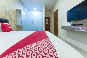 A hotel room with a bed, a red and white patterned bedspread, a television mounted on the wall, and a no smoking sign. - Collection O Yong Peng Near Dataran Gemilang Formerly H3 Hotel (Batu Pahat)