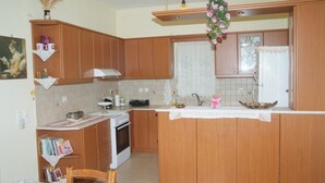 Una cocina con armarios de madera, una estufa blanca y una ventana con cortina.