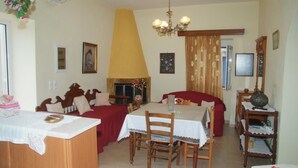 Un comedor con una mesa, sillas, una araña y una chimenea.