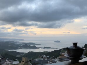Vista costeira com uma ilha distante, uma ponte e edifícios ao primeiro plano.
