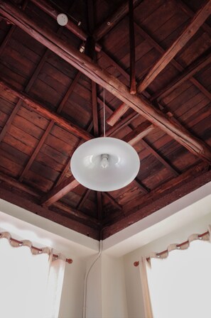 A room with a wooden ceiling, a white pendant light, and a window with a curtain. - Neat Hostel (Tainan)