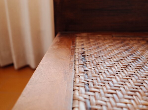 Primer plano de un tapete tejido con detalle de borde de madera.