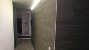 Un couloir doté d’un plancher en bois et d’un mur orné d’un motif texturé.
