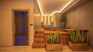 Un área de spa moderna con una escalera de madera, un jacuzzi y plantas en macetas.