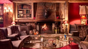 Una habitación acogedora con chimenea, estanterías y asientos cómodos.