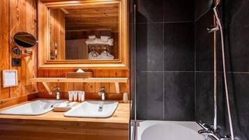 A wooden bathroom with two sinks, a mirror, and a shower.