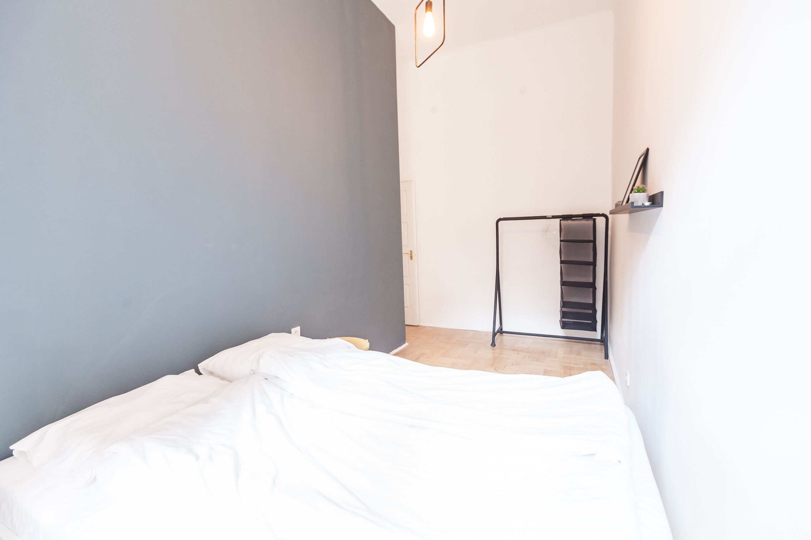 A room with a bed, a small desk, and a chair.