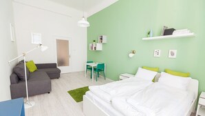 Un dormitorio moderno con una cama grande, un escritorio, un sofá y una silla.