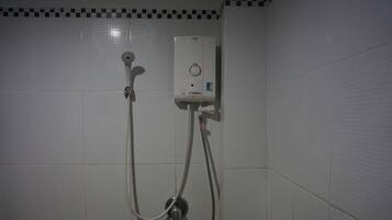 Baño con cabina de ducha, inodoro y paredes de azulejos.
