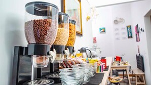 A coffee station with multiple dispensers filled with coffee beans and a coffee machine. - Di Palma Suite (Naples)