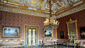 A grand room with ornate gold and white ceiling decorations, a chandelier, and a red rope barrier. - Di Palma Suite (Naples)