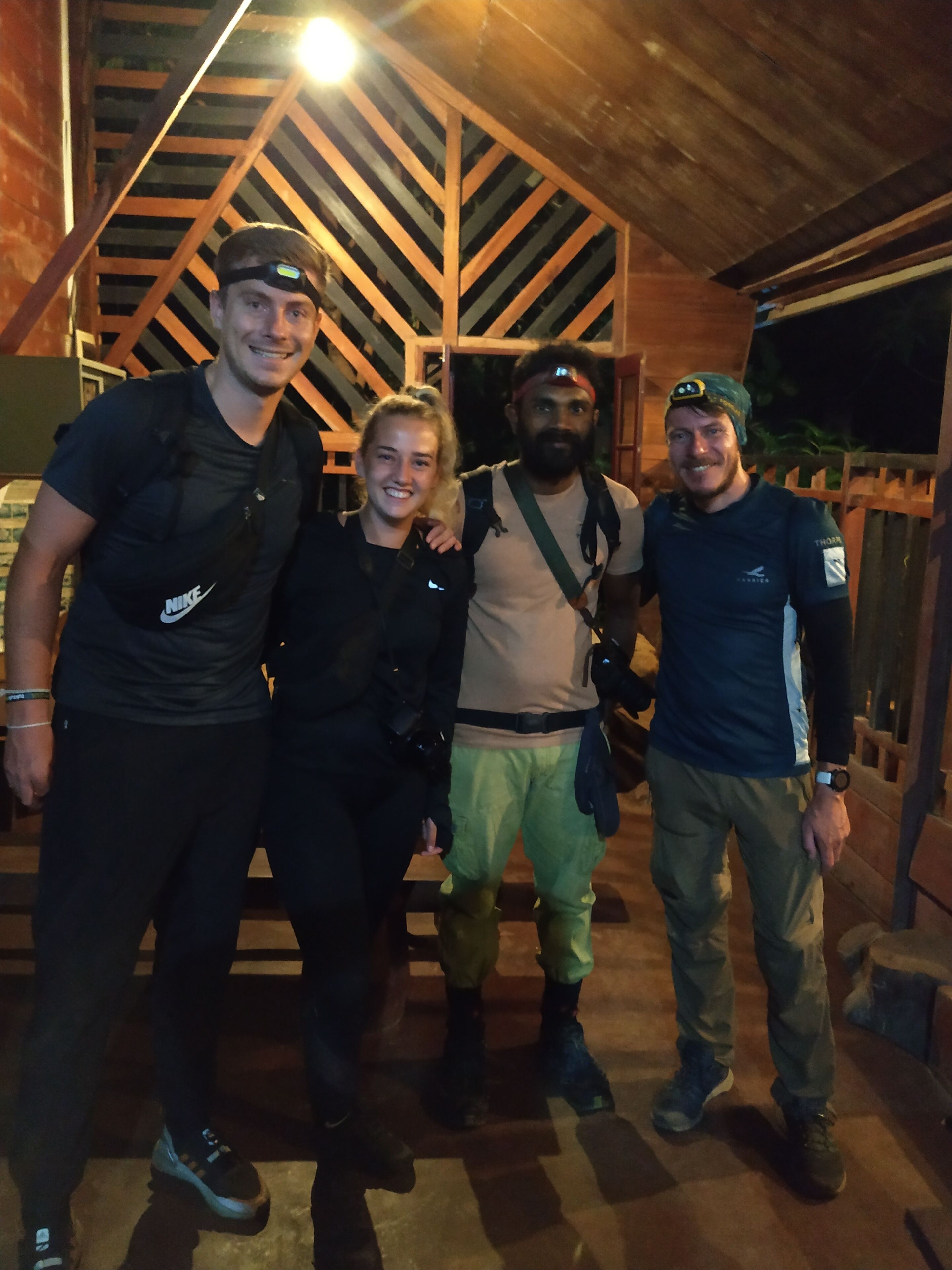 A group of people standing in a wooden structure with a sloped ceiling.
