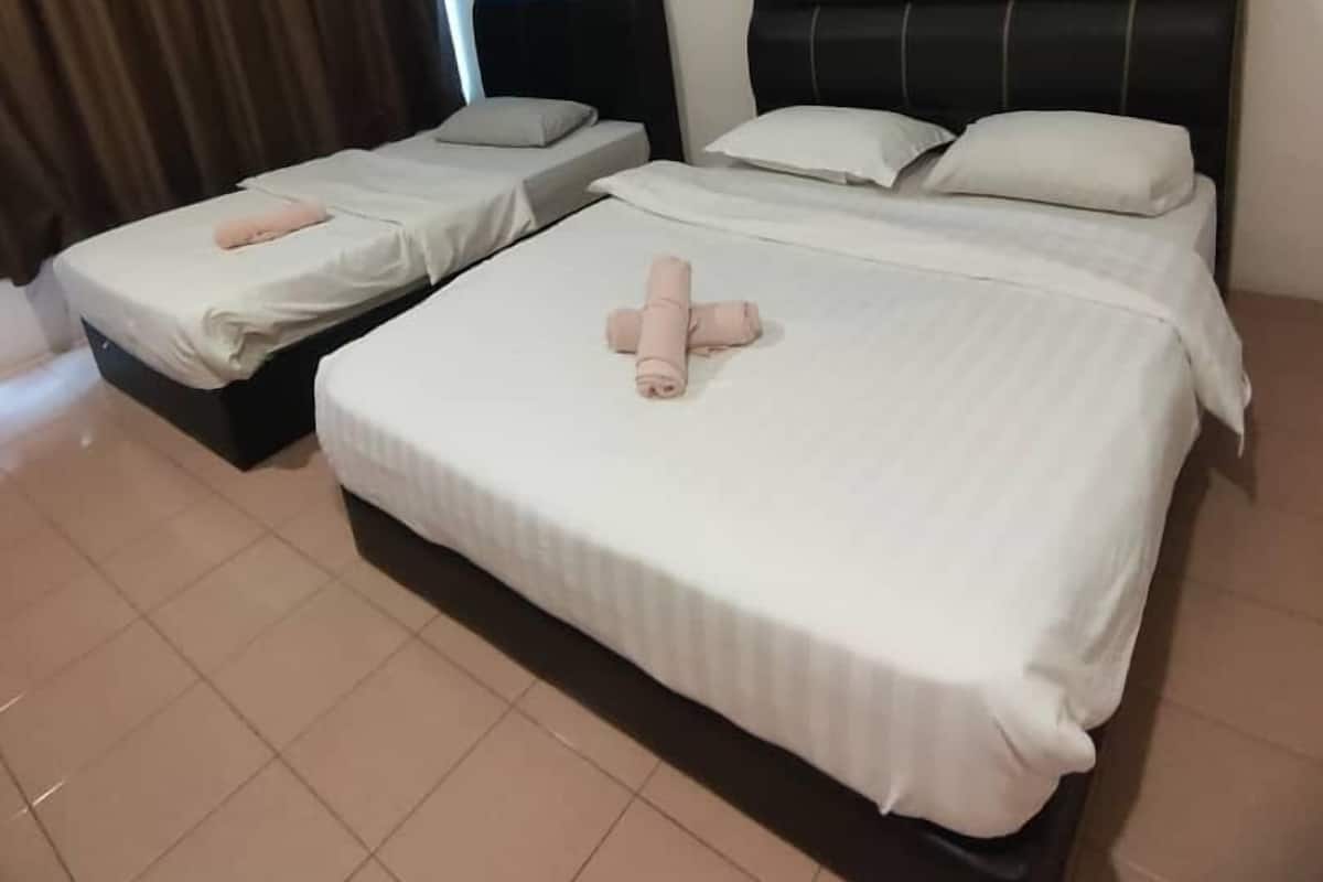 A hotel room with two beds, each with white linens and pillows.