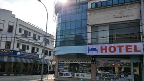 A hotel with a modern glass facade, a visible storefront with various items, and a sign indicating it is a hotel. - Anderson Hotel (Ipoh)