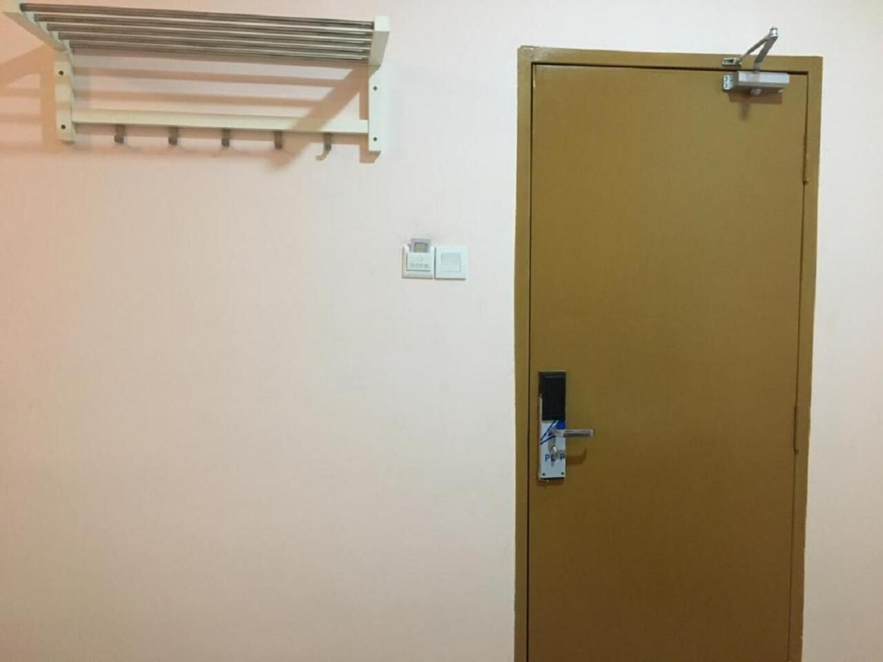 A door with a lock and a metal shelf above it.