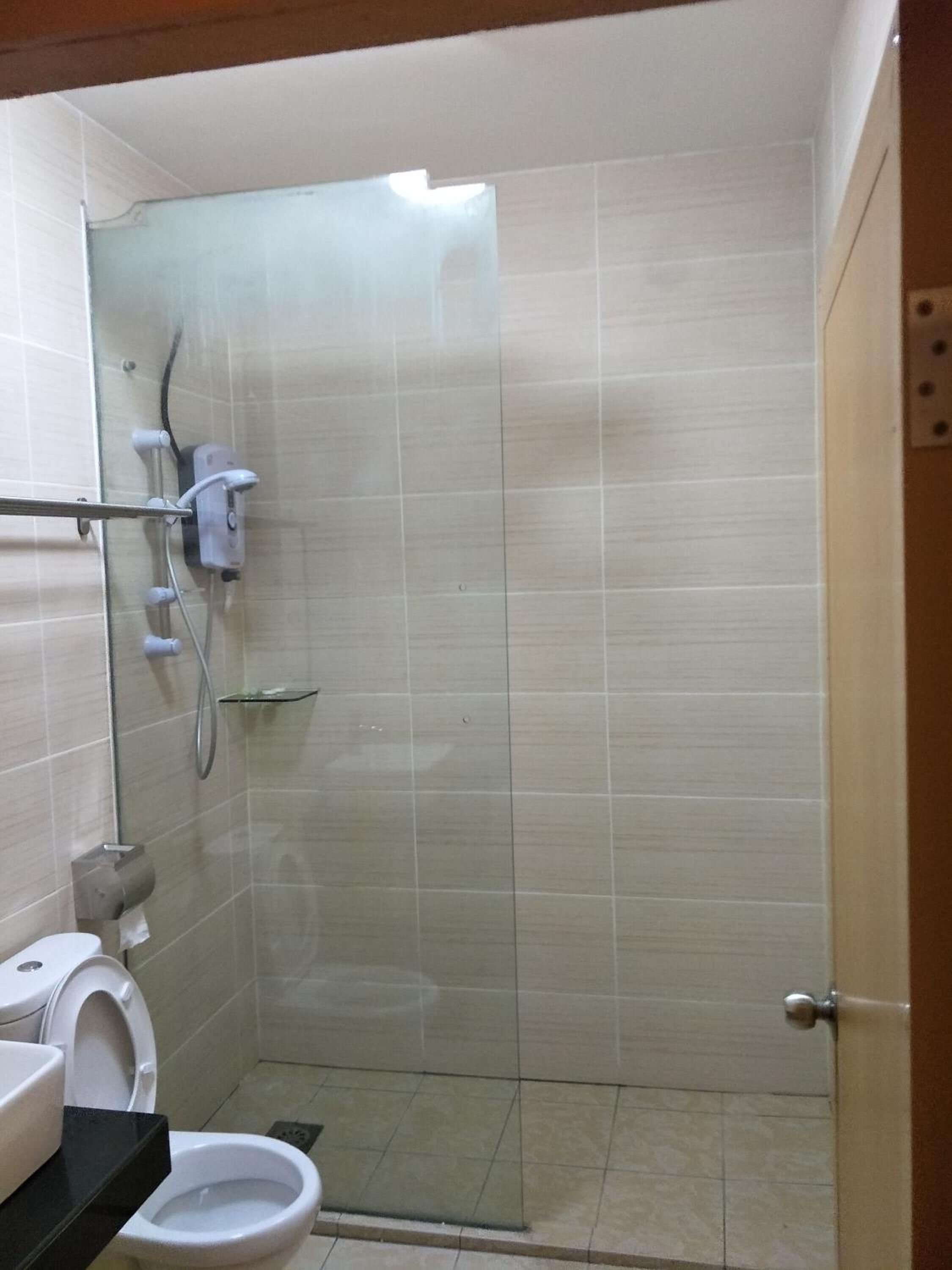 Un baño pequeño con azulejos, un inodoro, una ducha y un lavabo.