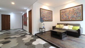 Una sala de estar moderna con sofá, mesa de centro y obras de arte en las paredes.