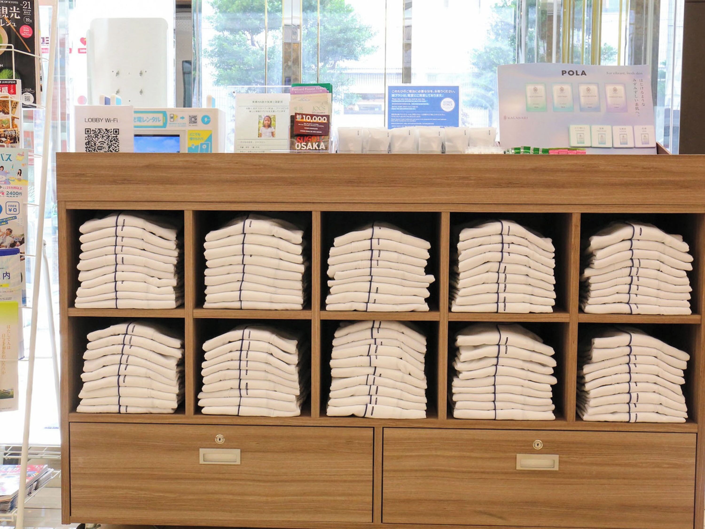 A neatly organized shelf with folded towels in a hotel setting.