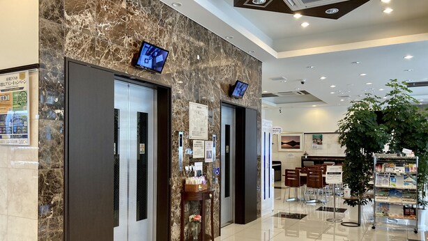 A hotel lobby with marble walls, a reception desk, and a seating area. - Toyoko Inn Shin Osaka Higashi Mikuni Station (Osaka)