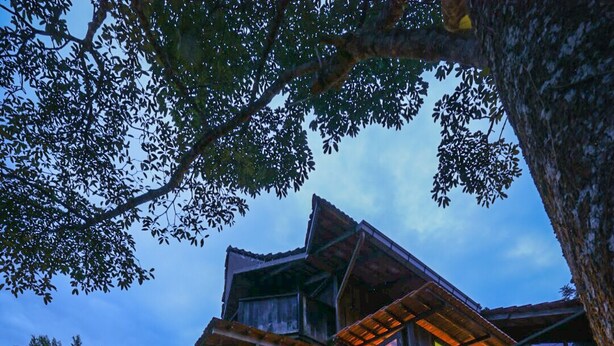 A wooden house with a balcony, outdoor seating, and a wooden deck. - Spyder Hill (Seremban)