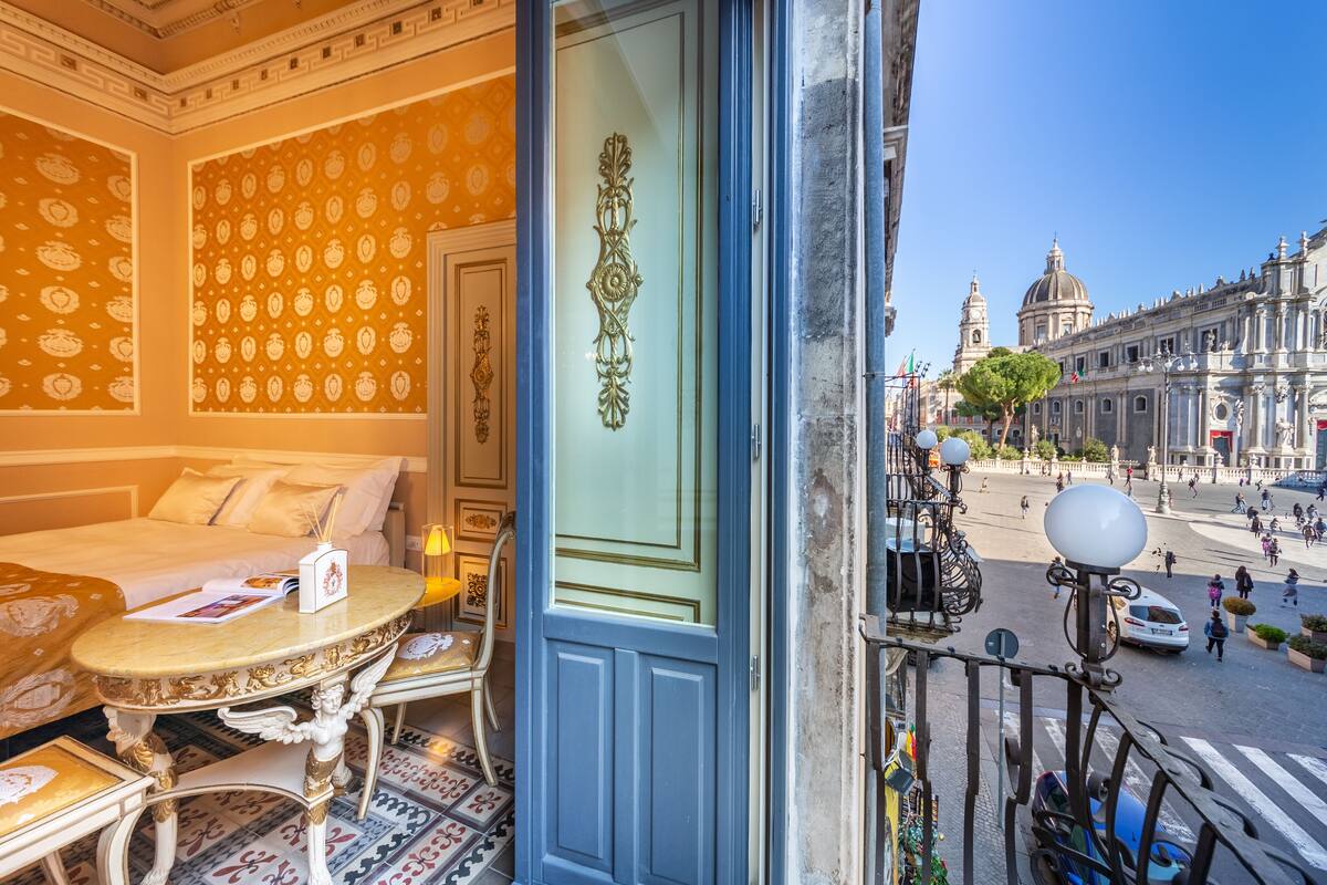 Habitación de hotel con cama, una mesa y vistas a la calle y edificios.