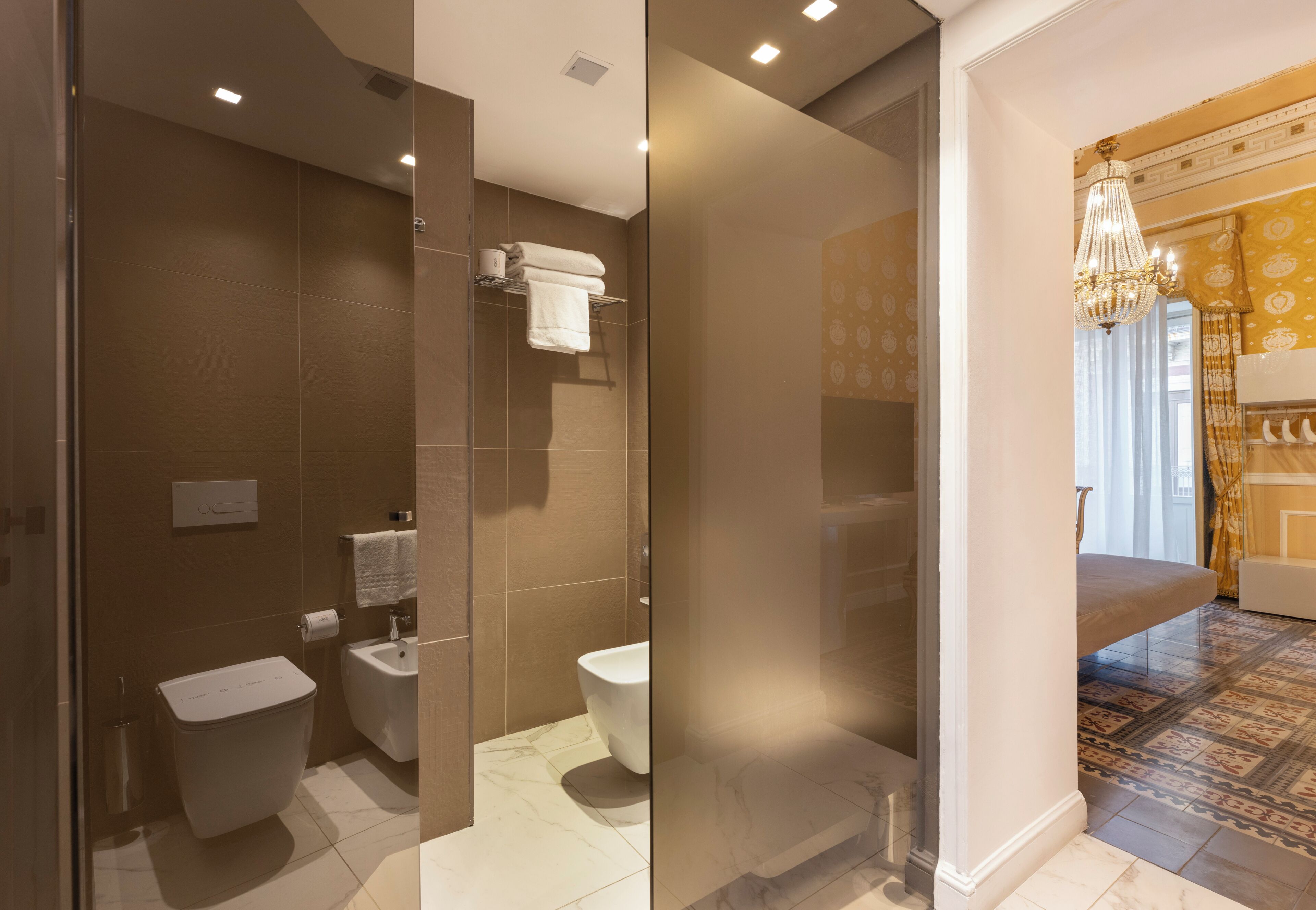 Une salle de bain moderne équipée de toilettes, d’un bidet et d’un porte-serviettes.